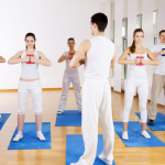 Group of people doing exercise with dumbbells.